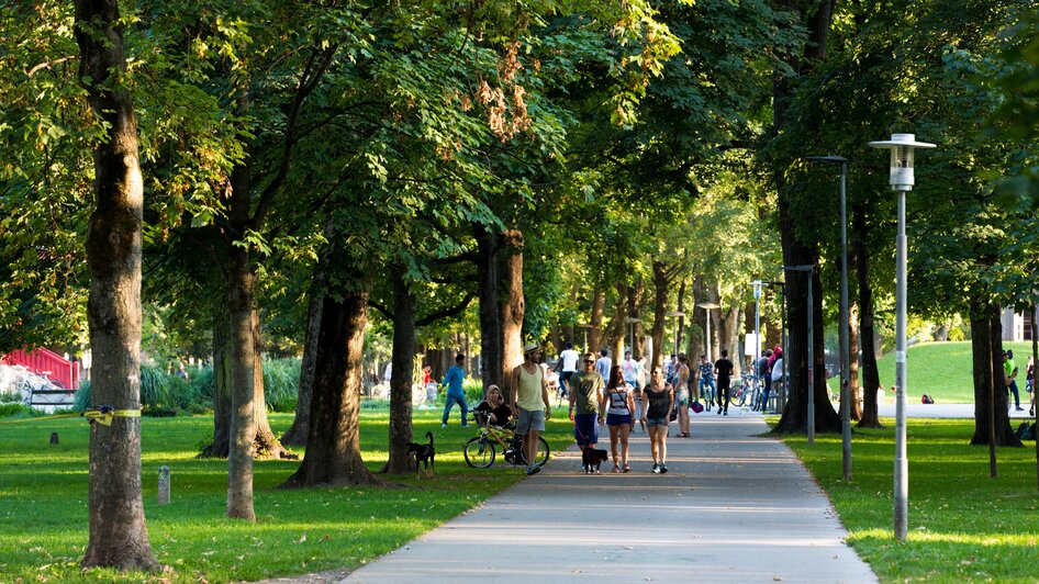 Spaziergang im Grazer Augarten an einem sonnigen Tag | © Graz Tourismus - Harry Schiffer Menschen spazieren gemütlich durch den Grazer Augarten. | © Graz Tourismus - Harry Schiffer