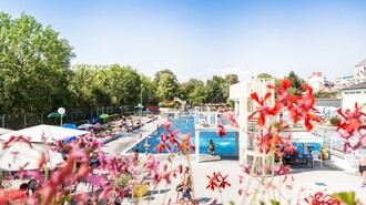 Blick auf das Augartenbad Graz mit vielen Besuchern und bunten Liegen. | © Holding Graz - Joel Kernasenko