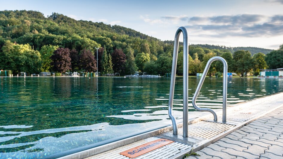 Ein Blick auf das Schwimmbecken im Bad Straßgang, umgeben von Bäumen. | © Holding Graz - Joel Kernasenko