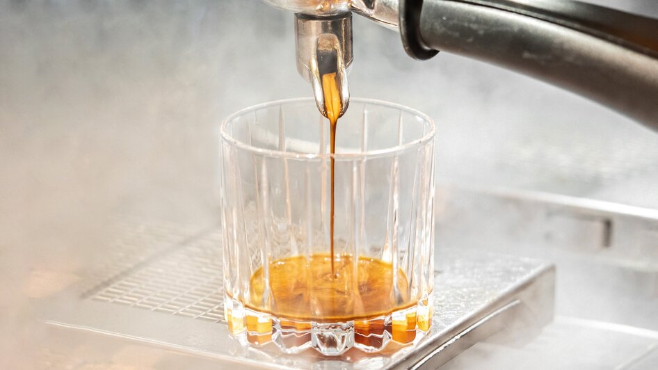 Ein Glas in das gerade frisch gebrühter Espresso eingegossen wird. | © Lucija Novak