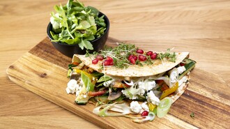 Vegetarische Quesadilla mit Salat auf Holzbrett serviert. | © Bistro Fino