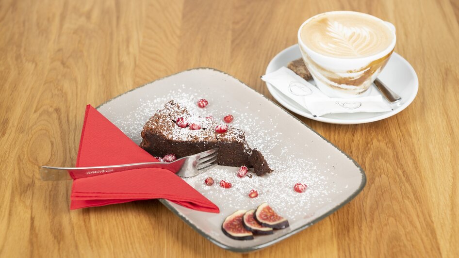 Ein Stück Schokoladenkuchen mit Himbeeren und eine Tasse Kaffee. | © Bistro Fino