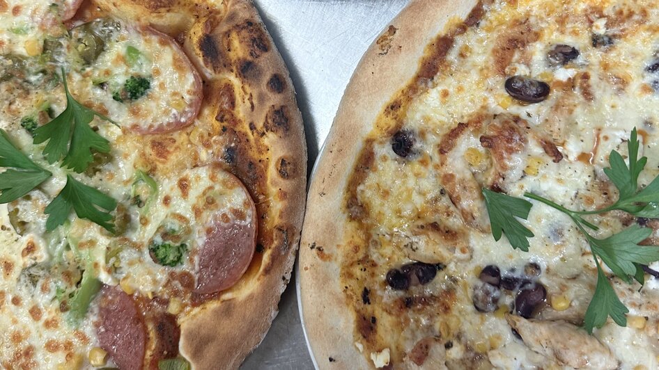 Drei verschiedene Pizzen auf einem Tisch, frisch zubereitet. | © Bonbon