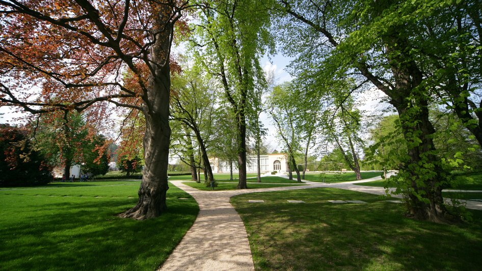 Weitläufiger Burggarten in Graz mit charakteristischen Bäumen und Wegen.