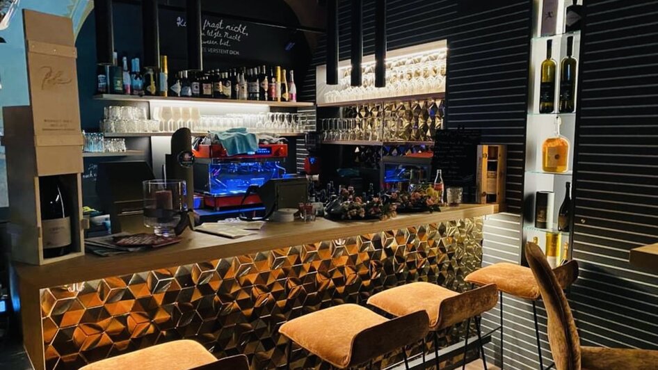 Moderne Bar mit goldener Theke und Getränken in Graz. | © Amaro
