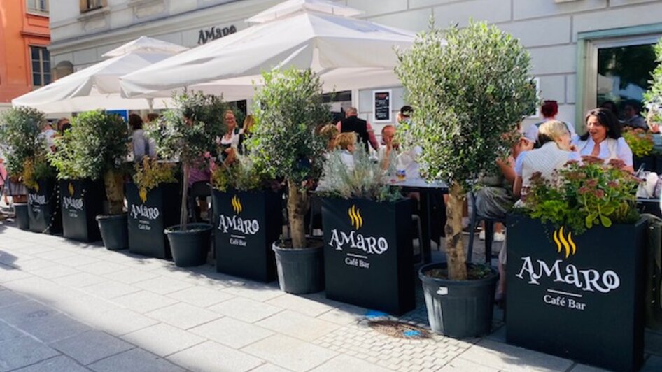 Gemütliches Café mit Pflanzen und Sonnenschirmen in Graz. | © Amaro