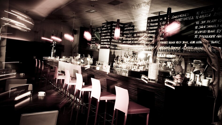 Stylische Bar mit beleuchteten Regalen und stimmungsvollem Ambiente. | © Cafe Glockenspiel