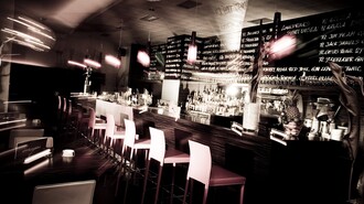 Stylische Bar mit beleuchteten Regalen und stimmungsvollem Ambiente. | © Cafe Glockenspiel