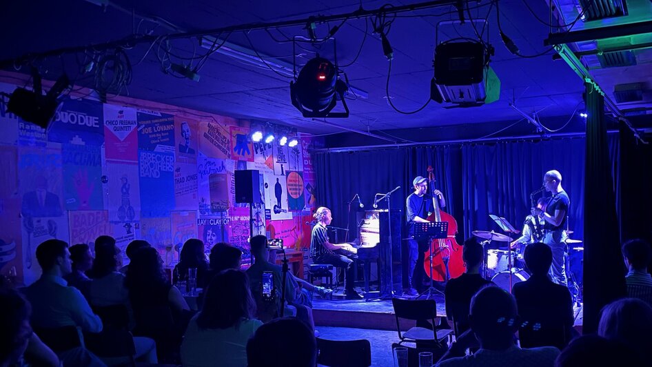 Jazzband spielt live in einer Bar, Publikum genießt die Musik. | © N. Popp