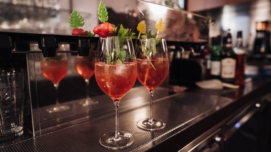Zwei Cocktails mit Früchten und Kräutern auf einer Bar in einem Café. | © Ripix