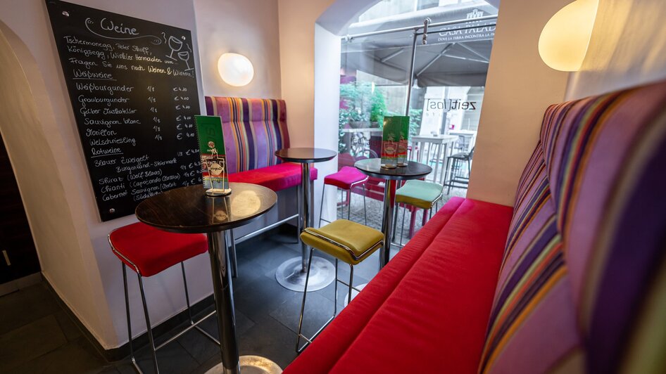 Ein modernes Café in Graz mit bunten Stühlen und einer Weinkarte. | © Ripix