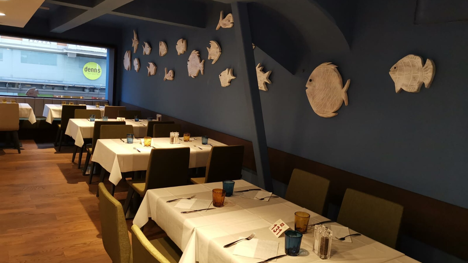Blick ins Restaurant mit Fischdekorationen an der Wand. | © Casa Costiera