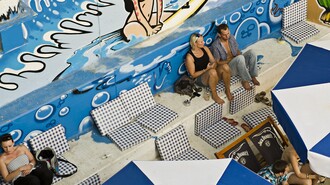 Blick auf eine Strandbar mit Graffiti und Sonnenliegen. | © Toni Muhr