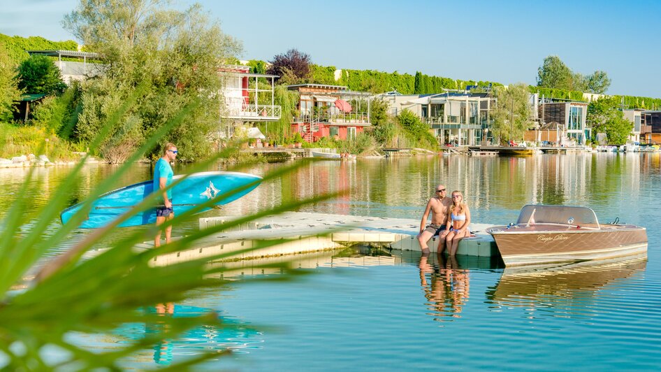 Entspannende Szene mit Paddler und Paar am See. | © Region Graz - Mias Photoart