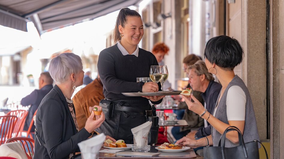 Bedienung im Restaurant mit Gästen in Graz.