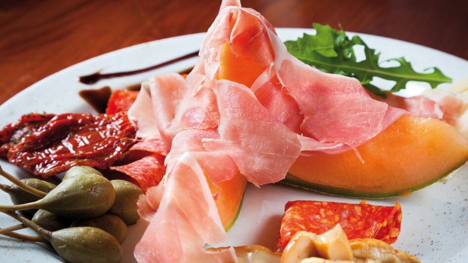 Eine Platte mit Prosciutto, Melone, Kapern und getrockneten Tomaten. | © Don Camillo