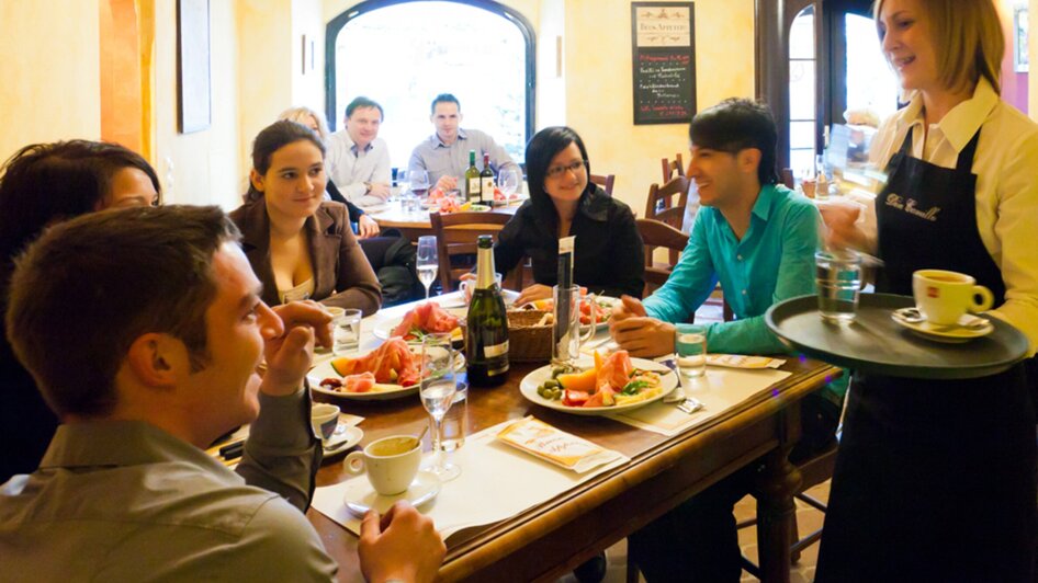 Geselliges Essen in einem Restaurant mit Gästen und Bedienung. | © Don Camillo