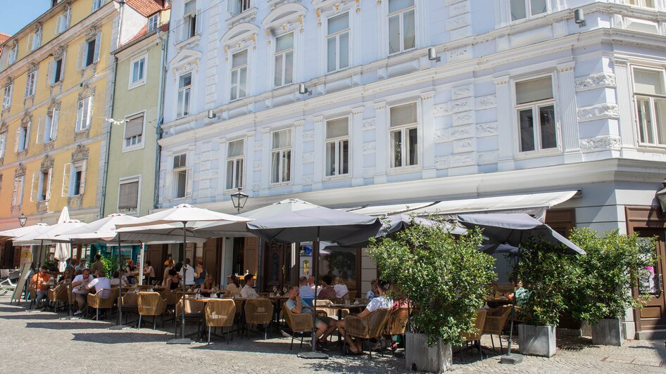 Besucher genießen das Essen im Gastgarten des Lokals dreizehn by Gauster in Graz. | © 5komma5sinne - Helmut Schweighofer