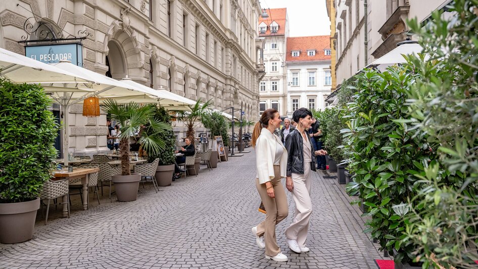 Zwei Frauen spazieren durch die Grazer Landhausgasse - vorbei am Restaurant "El Gaucho".
