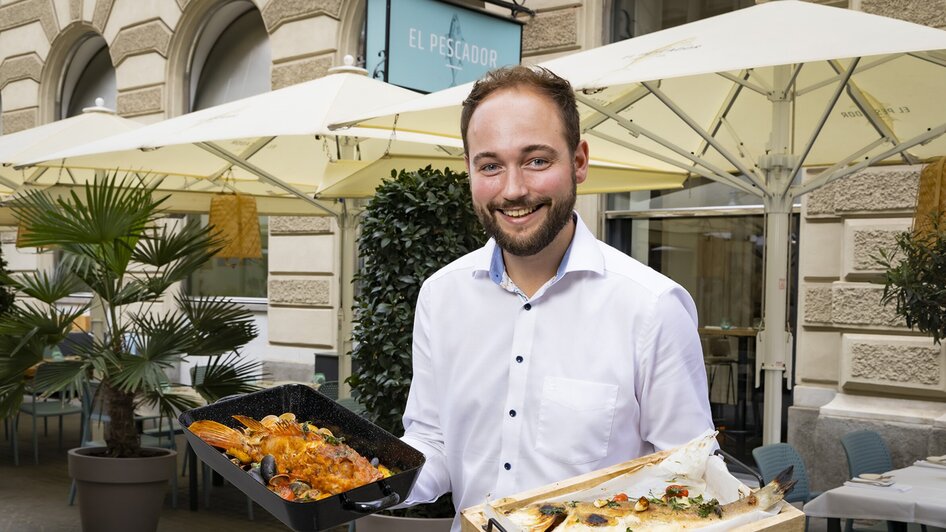 Ein lächelnder Mann mit Meeresfrüchten in einem Restaurant. | © El Pescador - Werner Krug