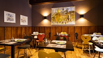 Gemütliches Restaurant mit bunten Stühlen und Wandkunst. | © Graz Tourismus - Werner Krug