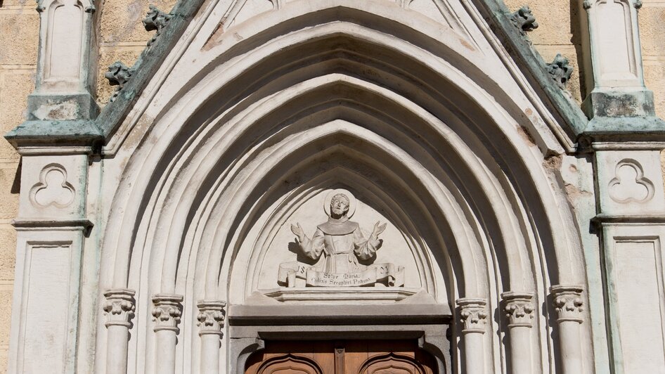 Detailansicht des Eingangs mit skulpturaler Darstellung im Franziskanerkloster in Graz.