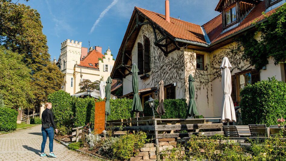 Idyllische Szene mit einer Buschenschank und Schloss Lustbühel im Hintergrund. | © Graz Tourismus - Mias Photoart