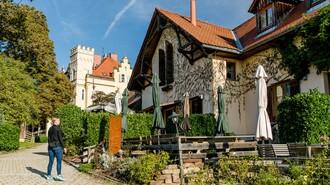 Idyllische Szene mit einer Buschenschank und Schloss Lustbühel im Hintergrund. | © Graz Tourismus - Mias Photoart