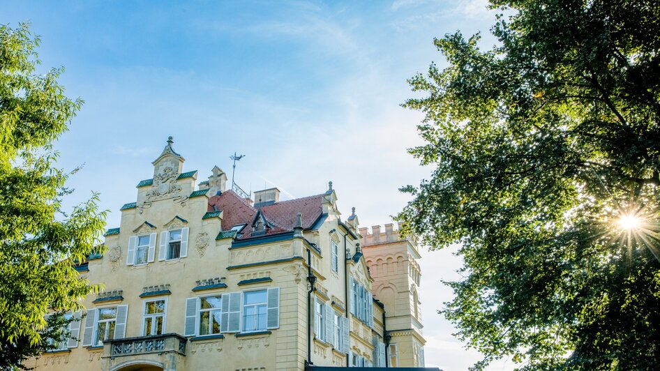 Schloss Lustbühel mit Türmen und Bäumen bei strahlendem Himmel in Graz. | © Graz Tourismus - Mias Photoart