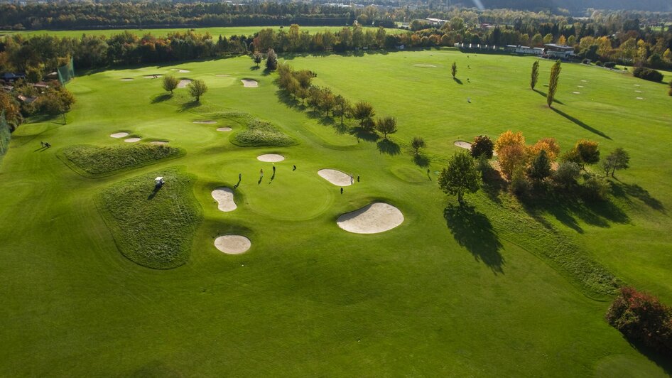 Weitblick über den Golfplatz mit Spielern in der Natur.