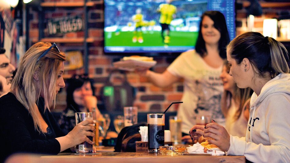 Gesellige Szene in einem Lokal mit Essen und Trinken. | © Heinz Burgers