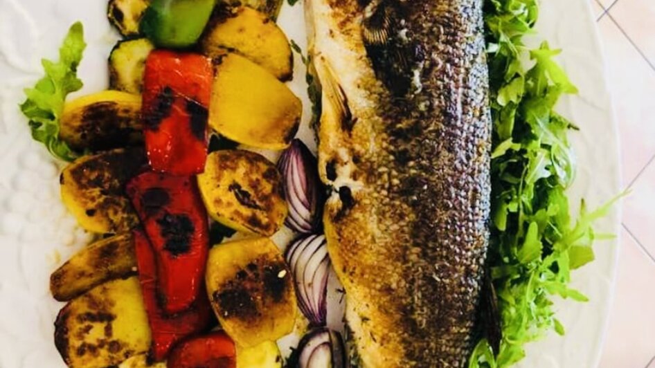 Leckerer gegrillter Fisch serviert mit buntem Gemüse und Zitrone. | © Il centro