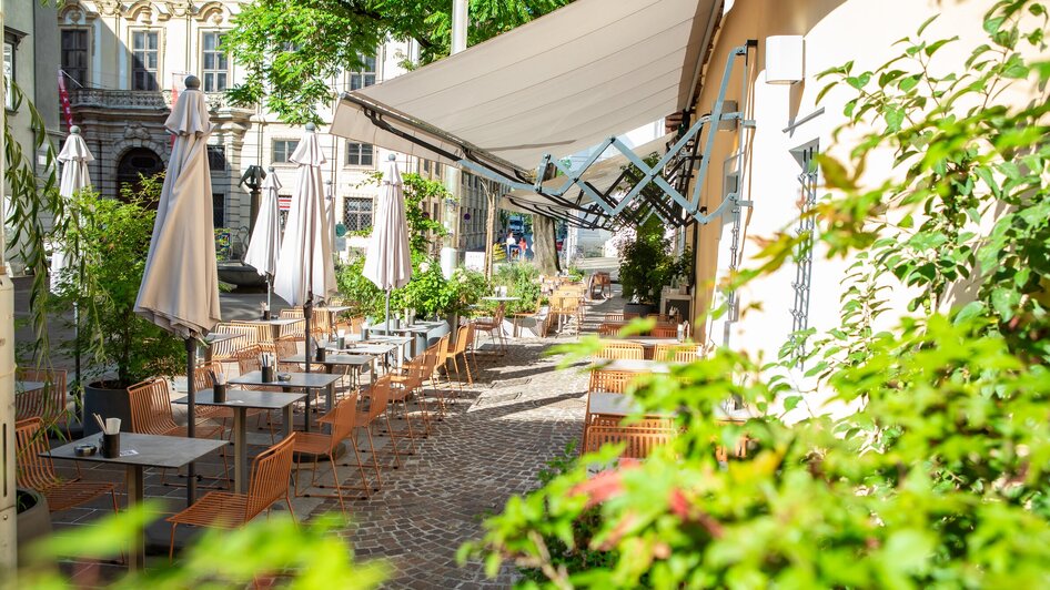 Entspannte Atmosphäre im Freiluftbereich eines Cafés in Graz.