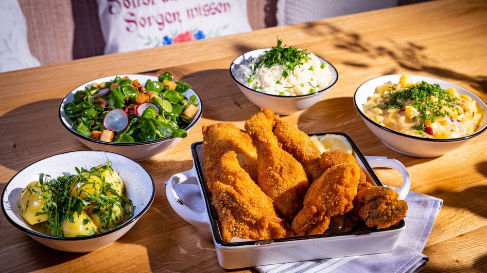 Knuspriges Backhendl mit Beilagen und frischen Salaten. | © Kreuzwirt am Rosenberg in Graz