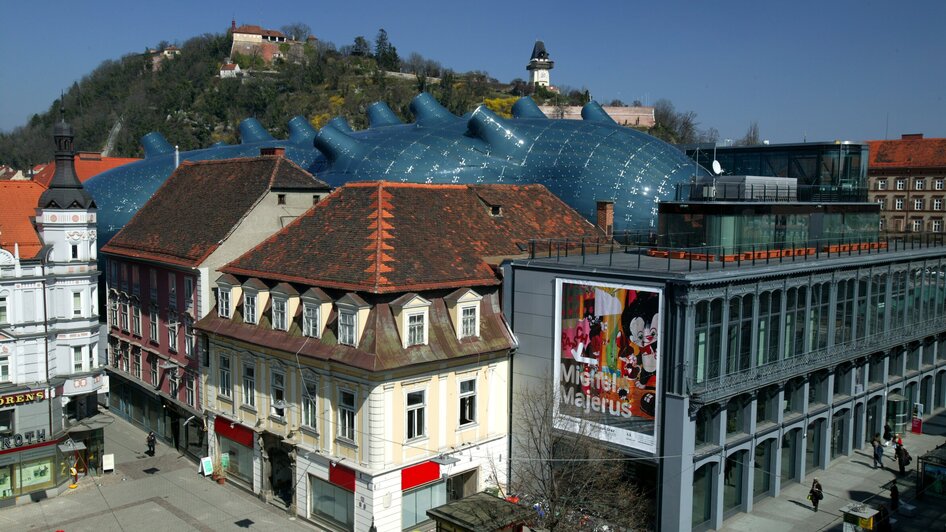 Blick auf das Kunsthaus Graz und den Grazer Uhrturm.
