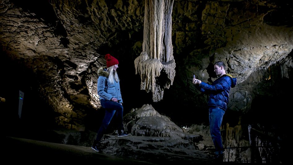 Zwei Personen erkunden die Lurgrotte Peggau, fotografieren Stalaktiten. | © Region Graz - Tom Lamm