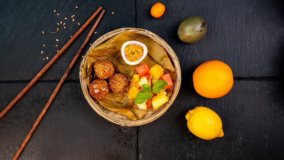 Ein Korb mit verschiedenen Früchten und Snacks, darunter süße Leckereien. | © Ma Kitchen