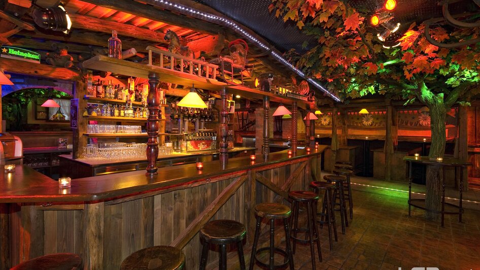 Gemütliche Bar mit bunten Lichtern und Holzdekor. | © Mausefalle +