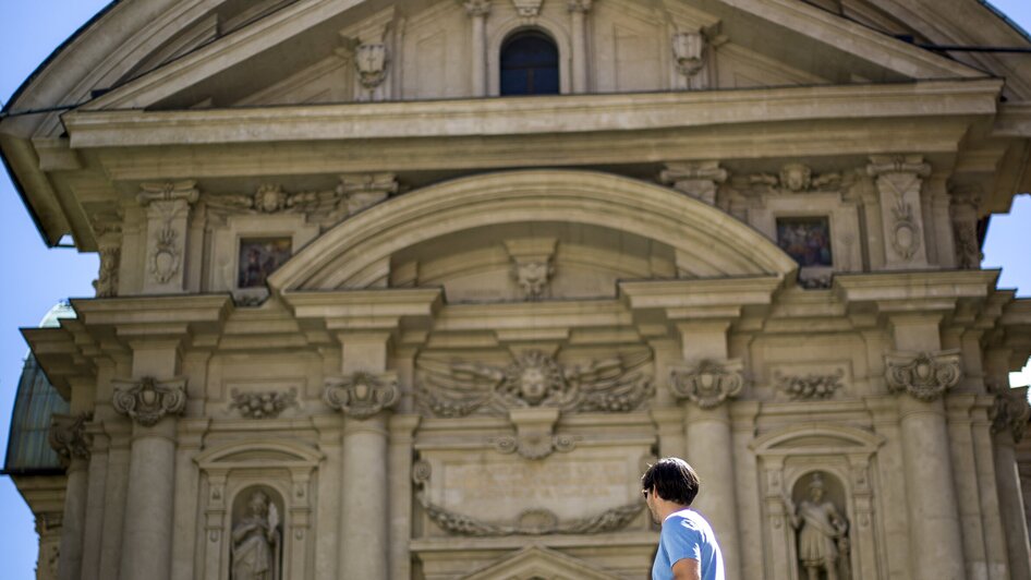 Paar sitzt auf Treppen vor dem beeindruckenden Mausoleum in Graz.