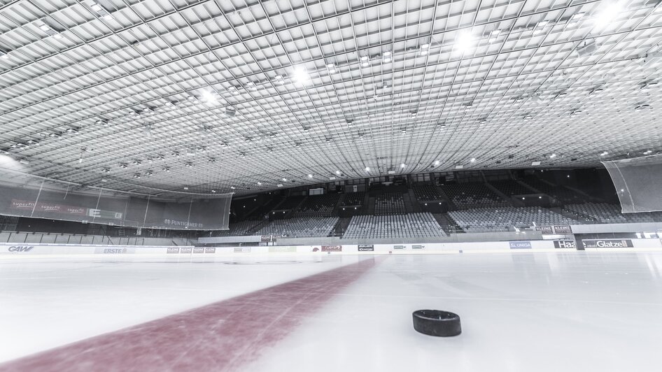 Leere Eisfläche mit Puck im Merkur Eisstadion in Graz.