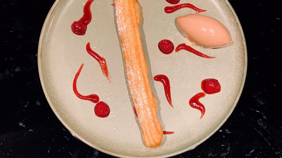 Dessert mit Churro und Sorbet, serviert auf einem Teller.