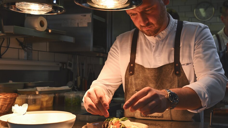 Ein Koch verfeinert eine Speise im Restaurant Mohrenwirt in Graz. | © 5komma5sinne - Rene Strasser Fotografie 