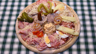 Ein Holzbrett mit verschiedenen Wurst- und Käseaufschnitten sowie Beilagen. | © Murheuriger