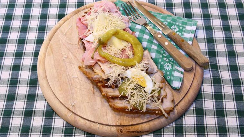 Ein Holzbrett mit einem Schinkenbrot mit Kren und Ei. | © Murheuriger