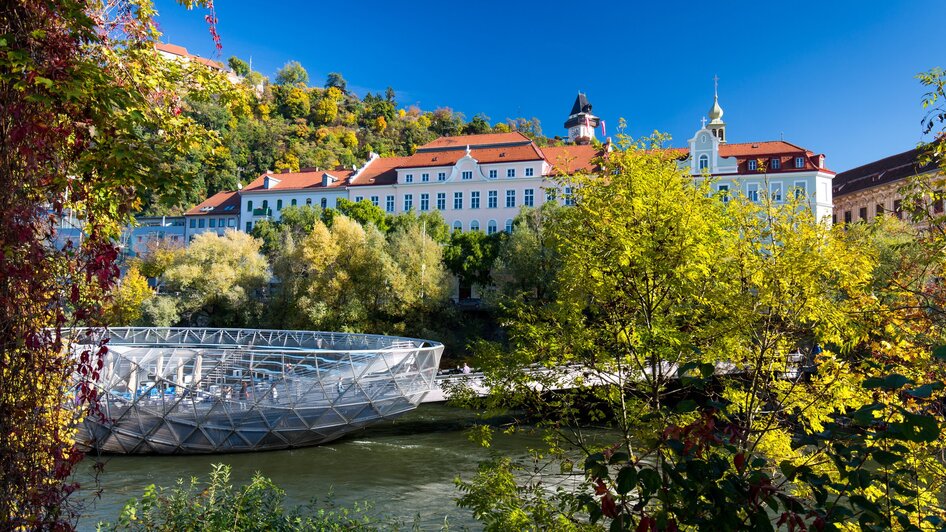 Die Murinsel in Graz vor malerischer Kulisse. | © Graz Tourismus - Harry Schiffer
