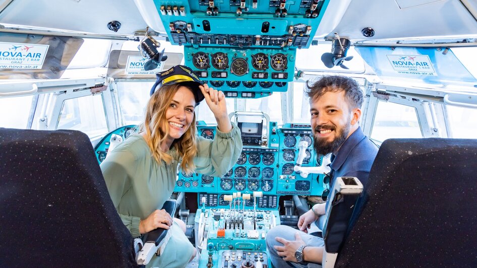 Zwei Personen im Cockpit eines Flugzeugs im Novapark Flugzeughotel Graz. | © Graz Tourismus - Werner Krug