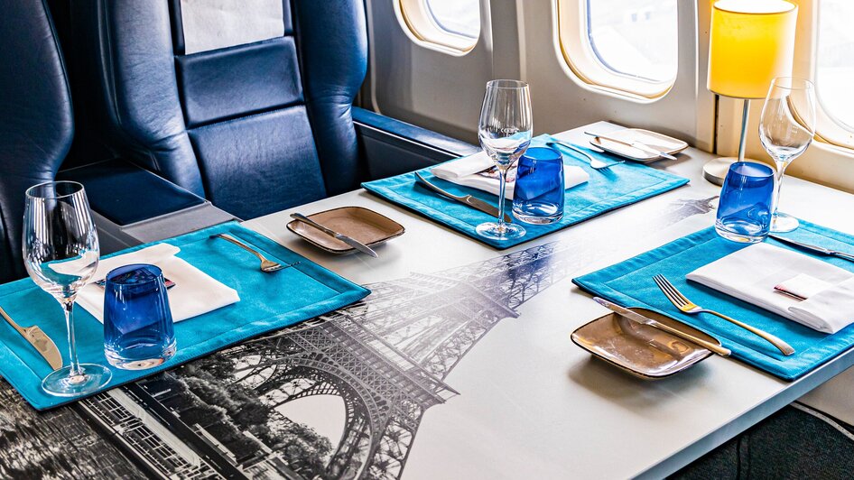 Elegantes Tischgedeck im Flugzeug-Restaurant mit blauem Geschirr. | © Graz Tourismus - Werner Krug