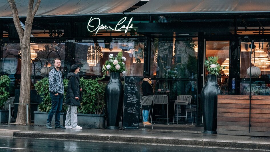 Zwei Personen stehen vor dem Operncafé in Graz, das in der Stadtmitte liegt.