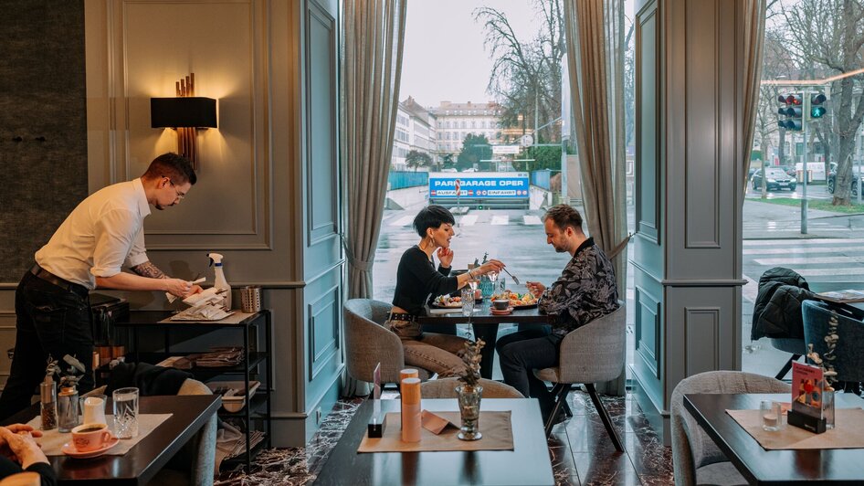 Gemütliches Ambiente im Operncafé in Graz mit Gästen und Servicepersonal.