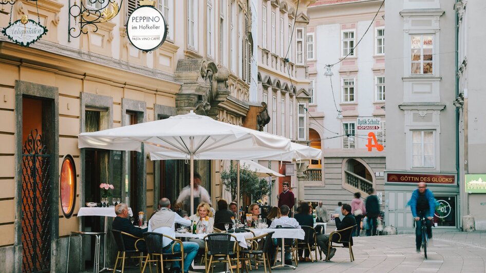 Gäste essen draußen bei Peppino im Hofkeller in Graz. | © Sebastian Reiser
